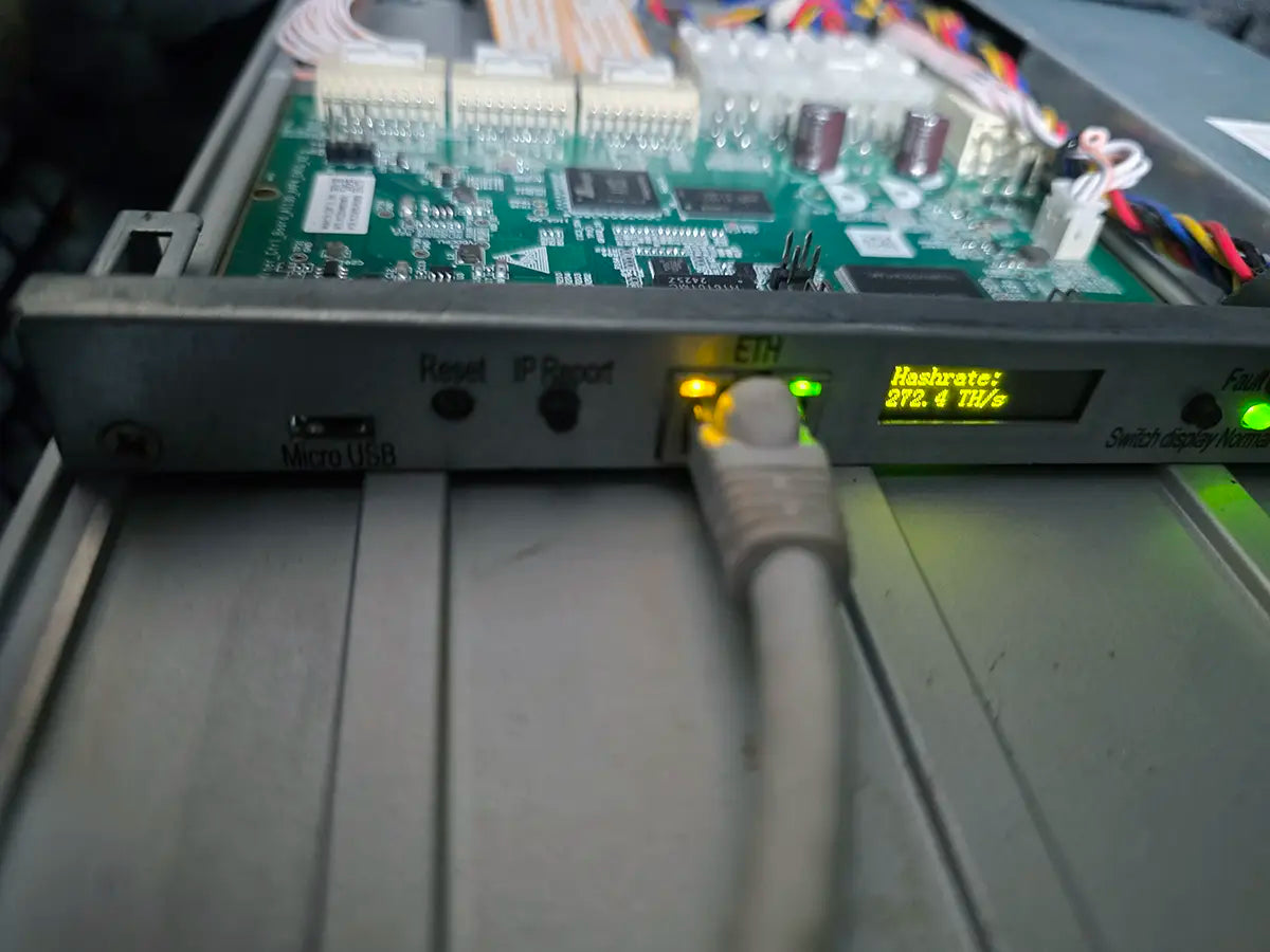 Front panel of an Antminer S21 control board after a firmware downgrade, with the Micro USB port, Reset and IP Report buttons, a live Ethernet link and the display reading Hashrate 272.4 TH/s